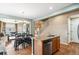 Bright kitchen with an island, stainless steel dishwasher and hardwood floors leading to the living room at 19602 E 63Rd Dr, Aurora, CO 80019