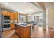 Open kitchen with a large island, granite countertops, stainless steel appliances, and hardwood floors at 19602 E 63Rd Dr, Aurora, CO 80019