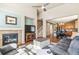 Spacious living room with a fireplace, hardwood floors, and an open view of the kitchen and dining area at 19602 E 63Rd Dr, Aurora, CO 80019