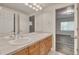 Bathroom featuring a double sink vanity with tile countertop, and views into the bedroom at 3535 Medallion Rd, Castle Rock, CO 80104