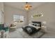 Bright bedroom featuring a comfortable bed, chair, and natural light from two windows at 3535 Medallion Rd, Castle Rock, CO 80104