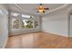 Large bedroom with hardwood floors, tray ceiling, and multiple windows at 3535 Medallion Rd, Castle Rock, CO 80104