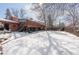 Snowy backyard with a deck, stairs, and mature trees, providing a serene outdoor setting for relaxation at 255 Iroquois Dr, Boulder, CO 80303