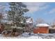 Charming home exterior with a red brick facade, attached two-car garage, and mature trees covered in snow at 255 Iroquois Dr, Boulder, CO 80303