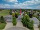 Aerial view of charming home in a neighborhood with lush green trees and spacious yards under a bright blue cloudy sky at 9079 Garnet St, Highlands Ranch, CO 80126