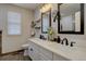 Stylish bathroom with double vanity sinks, modern faucets, open shelving, and a window for natural light at 9079 Garnet St, Highlands Ranch, CO 80126