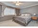 Comfortable bedroom with neutral gray walls, plush carpeting, a metal bed frame and large window at 9079 Garnet St, Highlands Ranch, CO 80126