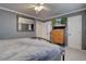 Comfortable bedroom with gray walls, a full bed, a ceiling fan and a mounted television at 9079 Garnet St, Highlands Ranch, CO 80126
