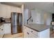 Modern kitchen featuring stainless steel refrigerator, large island, and custom cabinets for ample storage at 9079 Garnet St, Highlands Ranch, CO 80126