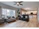 Open concept living room featuring hardwood floors, large windows, and a modern ceiling fan at 9079 Garnet St, Highlands Ranch, CO 80126