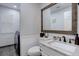 Charming powder room featuring a rustic wood-framed mirror and a marble countertop vanity with a laundry room nearby at 9079 Garnet St, Highlands Ranch, CO 80126