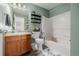 Charming bathroom with light green walls, bathtub, and wood cabinets at 12713 Leyden St # F, Thornton, CO 80602