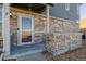 Townhome front entrance with stonework, welcoming mat, and glass door at 12713 Leyden St # F, Thornton, CO 80602