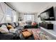 Spacious living room featuring a sectional sofa, large TV, and barn door accents at 12713 Leyden St # F, Thornton, CO 80602