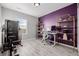 Home office with a desk, shelving, and a purple accent wall at 12713 Leyden St # F, Thornton, CO 80602