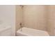 Tiled bathtub and shower combo features neutral tones at 7665 E Eastman Ave # 106A, Denver, CO 80231