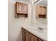Bathroom featuring a bright vanity, wood cabinets, and a large mirror at 7665 E Eastman Ave # 106A, Denver, CO 80231