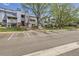 Light blue condominium building with multiple units and balconies, featuring well-maintained landscaping and ample parking spaces at 7665 E Eastman Ave # 106A, Denver, CO 80231