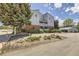 Light blue condo building features brick accents, landscaped gardens, and a view of the parking area, showcasing the property's exterior at 7665 E Eastman Ave # 106A, Denver, CO 80231