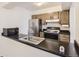 Functional kitchen with black countertops, stainless steel appliances, and plenty of cabinet storage at 7665 E Eastman Ave # 106A, Denver, CO 80231