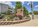 Stone sign with the name 'Shadow Wood' surrounded by manicured landscaping and a partial view of the light blue buildings at 7665 E Eastman Ave # 106A, Denver, CO 80231