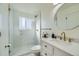 Elegant bathroom with marble shower, white vanity, and gold fixtures at 9749 Steele St, Thornton, CO 80229