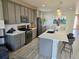 Beautiful kitchen featuring stainless appliances, gray cabinets, white backsplash, and an island with barstool seating at 16111 Alberta Dr, Parker, CO 80134