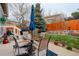 Inviting backyard patio with glass table, seating, blue umbrella and a lush lawn at 20715 Bridlewood Ln, Parker, CO 80138