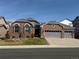 Charming brick home featuring a well-manicured front yard and an attached three-car garage at 20715 Bridlewood Ln, Parker, CO 80138