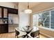 Bright kitchen nook with large windows, dark cabinets, stainless steel refrigerator, and a glass table at 20715 Bridlewood Ln, Parker, CO 80138