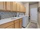 Functional laundry room with modern appliances, ample cabinetry, and a utility sink at 20715 Bridlewood Ln, Parker, CO 80138