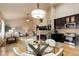Open floor plan with kitchen and living area featuring dark cabinets, modern lighting, and fireplace at 20715 Bridlewood Ln, Parker, CO 80138