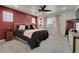 Inviting bedroom featuring a red accent wall, plush bedding, and plenty of natural light at 16818 E 119Th Ave # A, Commerce City, CO 80022