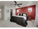 Comfortable bedroom featuring a red accent wall and adjacent closet at 16818 E 119Th Ave # A, Commerce City, CO 80022
