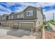 Street view showing garages with modern townhome, stone accents, and landscaped areas at 16818 E 119Th Ave # A, Commerce City, CO 80022