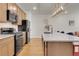 Modern kitchen with stone counters, stainless appliances, and tan cabinets at 16818 E 119Th Ave # A, Commerce City, CO 80022
