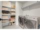 Well-organized laundry room with shelving and stainless steel washer and dryer at 16818 E 119Th Ave # A, Commerce City, CO 80022