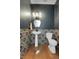 Stylish powder room featuring unique patterned tile, geometric mirror, and modern fixtures at 16818 E 119Th Ave # A, Commerce City, CO 80022