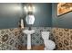 Stylish powder room featuring unique patterned tile, geometric mirror, and modern fixtures at 16818 E 119Th Ave # A, Commerce City, CO 80022