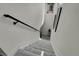 Well-lit staircase with carpeted steps and a sleek black handrail leading to upper level at 16818 E 119Th Ave # A, Commerce City, CO 80022
