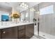 Modern bathroom with double sinks, granite countertops, a glass-enclosed shower, and tiled walls at 16351 Askins Loop, Parker, CO 80134