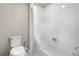 Clean bathroom featuring a shower-tub combination, white tile, and modern toilet at 16351 Askins Loop, Parker, CO 80134