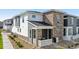 Attractive townhome with stone accents, neutral siding, and inviting front porch at 16351 Askins Loop, Parker, CO 80134