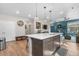 Open-concept kitchen with island bar, undermount sink, and hardwood flooring extending into the living area at 16351 Askins Loop, Parker, CO 80134