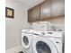 Laundry room with Samsung washer and dryer and upper cabinets at 16351 Askins Loop, Parker, CO 80134