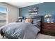 Comfortable main bedroom featuring a blue accent wall, window, and stylish decor at 16351 Askins Loop, Parker, CO 80134