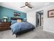 Main bedroom with a blue accent wall, carpeting, and a glimpse into an attached walk-in closet at 16351 Askins Loop, Parker, CO 80134