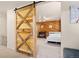 A sliding wooden barn door provides access to a room with wood paneled walls and carpet flooring at 2773 S Lansing Way, Aurora, CO 80014