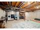 Unfinished basement featuring laundry area, utility sink, and workout equipment, offering potential for customization at 2773 S Lansing Way, Aurora, CO 80014