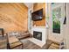Cozy living room showcasing a fireplace, wood paneling, and ample natural light at 2773 S Lansing Way, Aurora, CO 80014